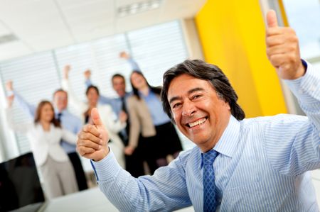 Happy man with thumbs-up leading a successful business team