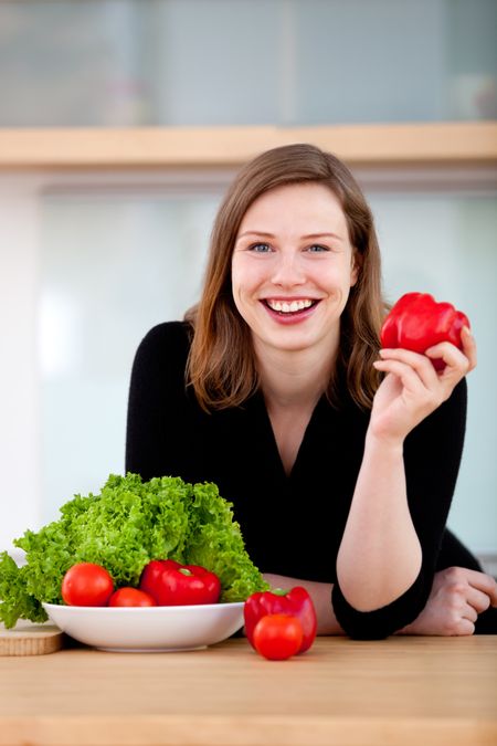 Healthy eating woman preparing a vegetable salad and smiling