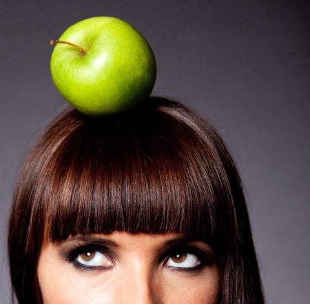 Woman thinking on a healthy diet with an apple on her head