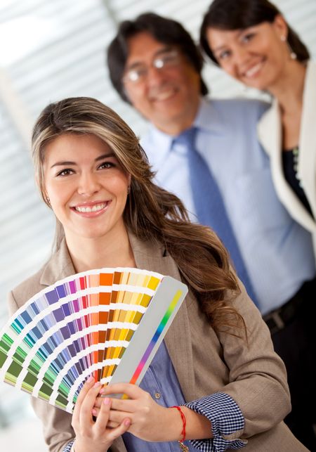 Business couple with an interior designer choosing a color to paint the office