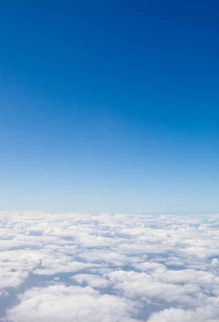 Beautiful blue sky seen from an airplane with clouds at the bottom