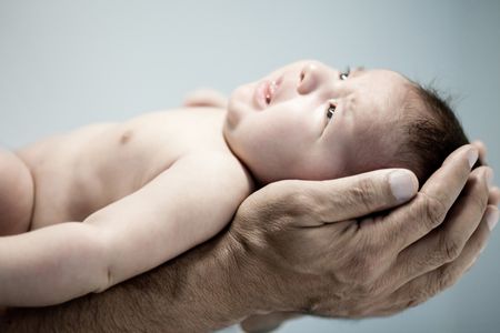 Male holding a newborn in his hands - human protection