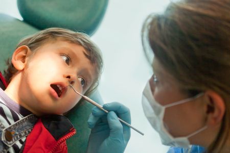 Dentist looking at a little boys teeth