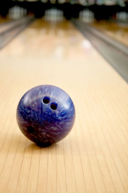 Close-up of a purple bowling ball in an alley