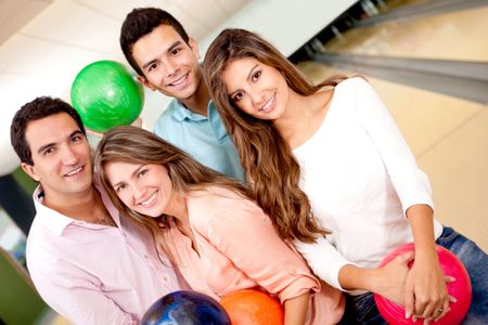 Group of friends having fun bowling and smiling