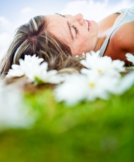 Happy casual woman lying outdoors and relaxing