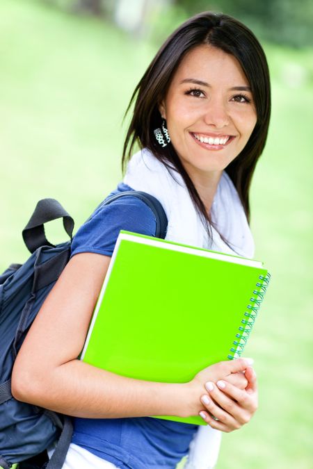Happy female student with backpack and notebooks smiling