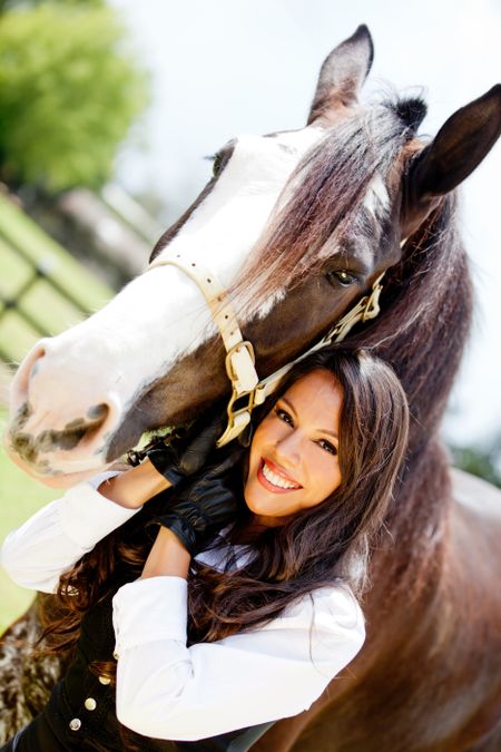 Portrait of a beautiful woman with a horse outdoors