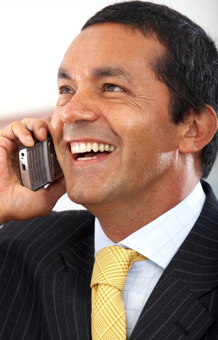 Business man talking on the phone smiling in his office