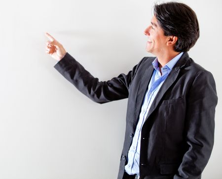 Businessman pointing at the wall - isolated over a white background